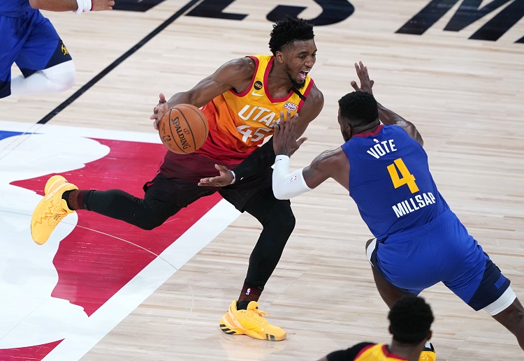 Utah Jazz's Donovan Mitchell playing the ball against Denver Nuggets' Paul Millsap during the NBA Playoffs